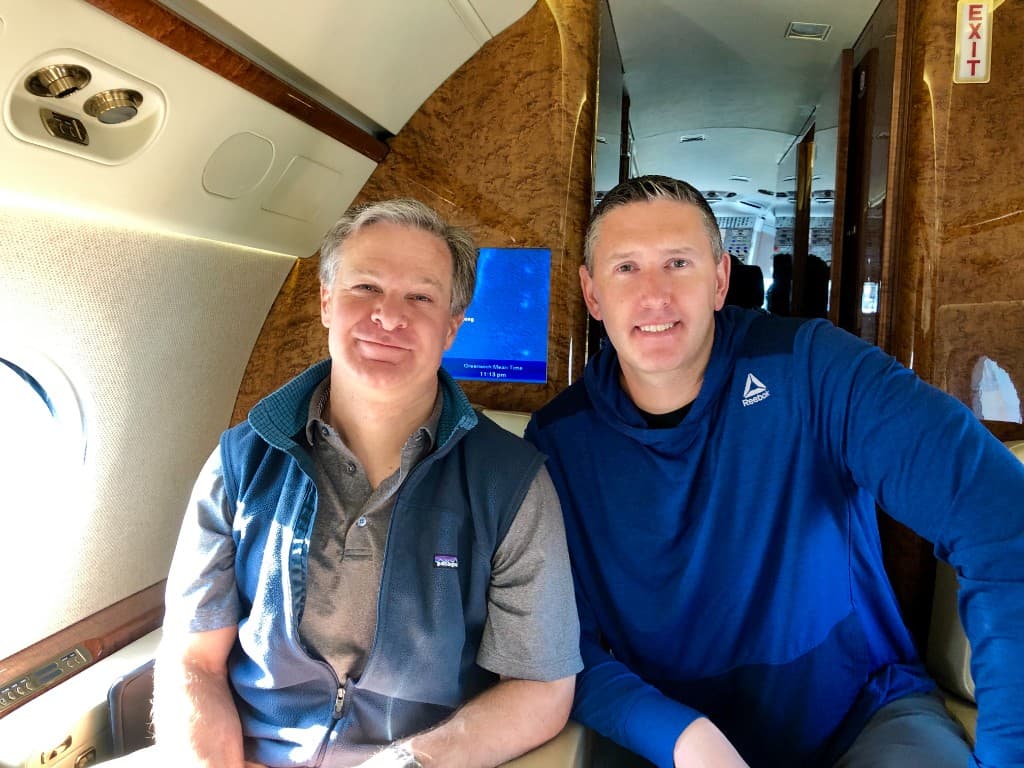 Rob Gunderson seated aboard a private aircraft with a colleague