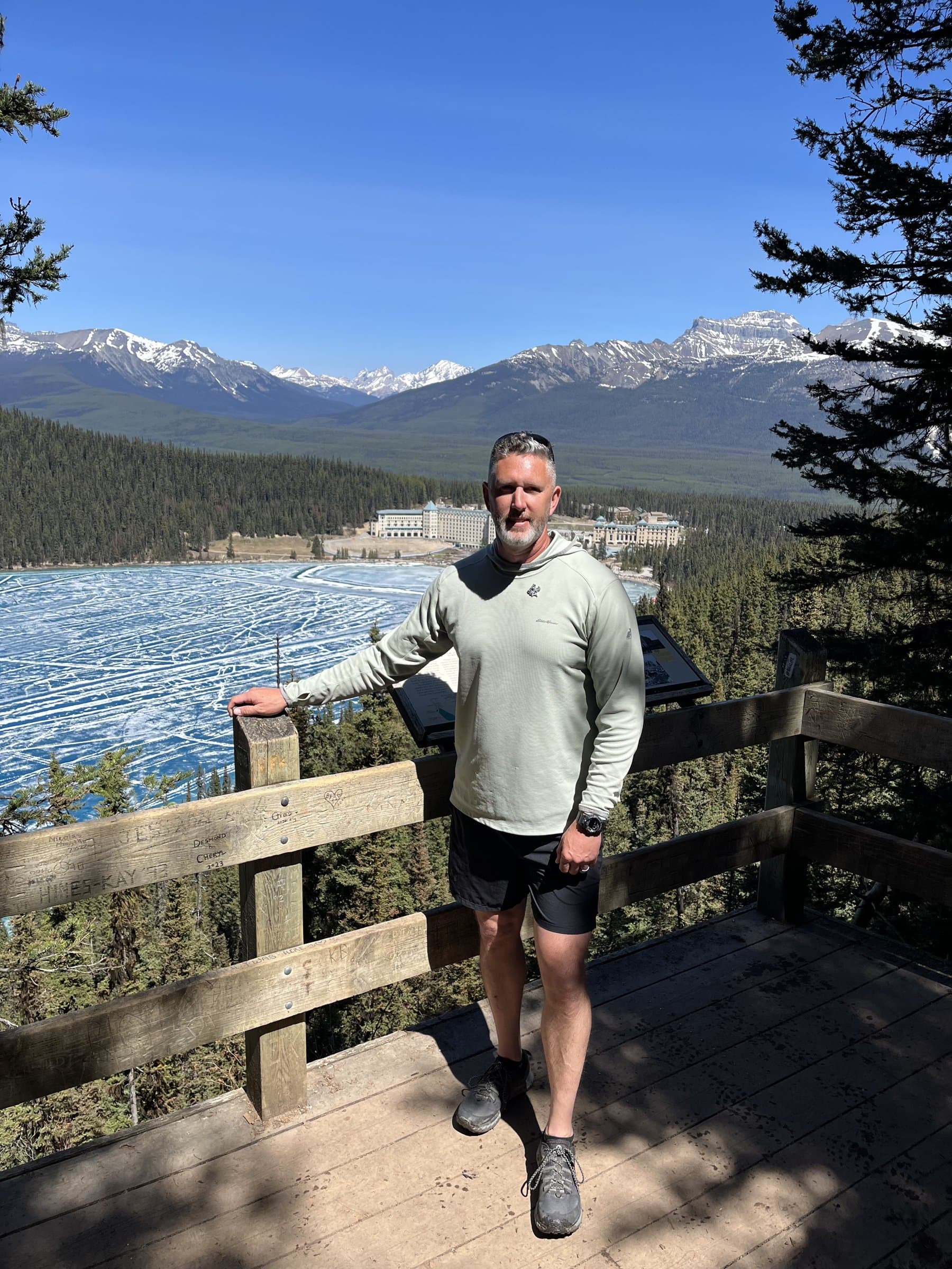 Rob Gunderson standing on a wooden overlook above a frozen lake and mountains in Banff National Park