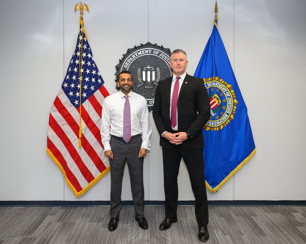 Rob Gunderson standing with FBI Director Kash Patel in front of the American flag and the FBI flag