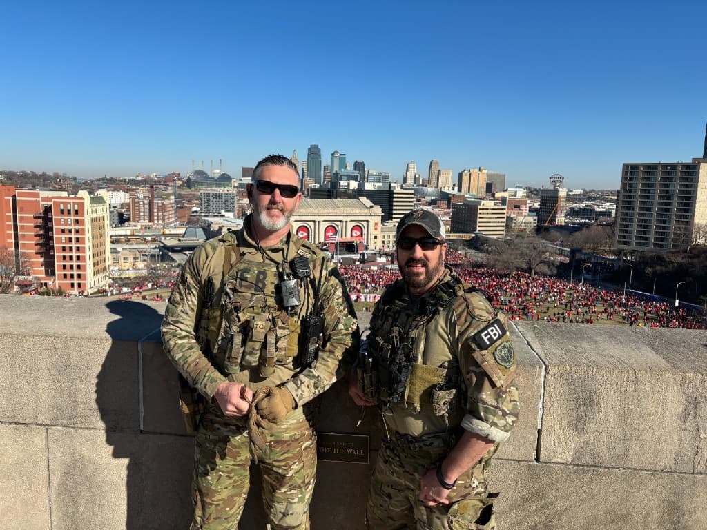 Rob Gunderson with an FBI teammate on a Kansas City rooftop overlooking a parade